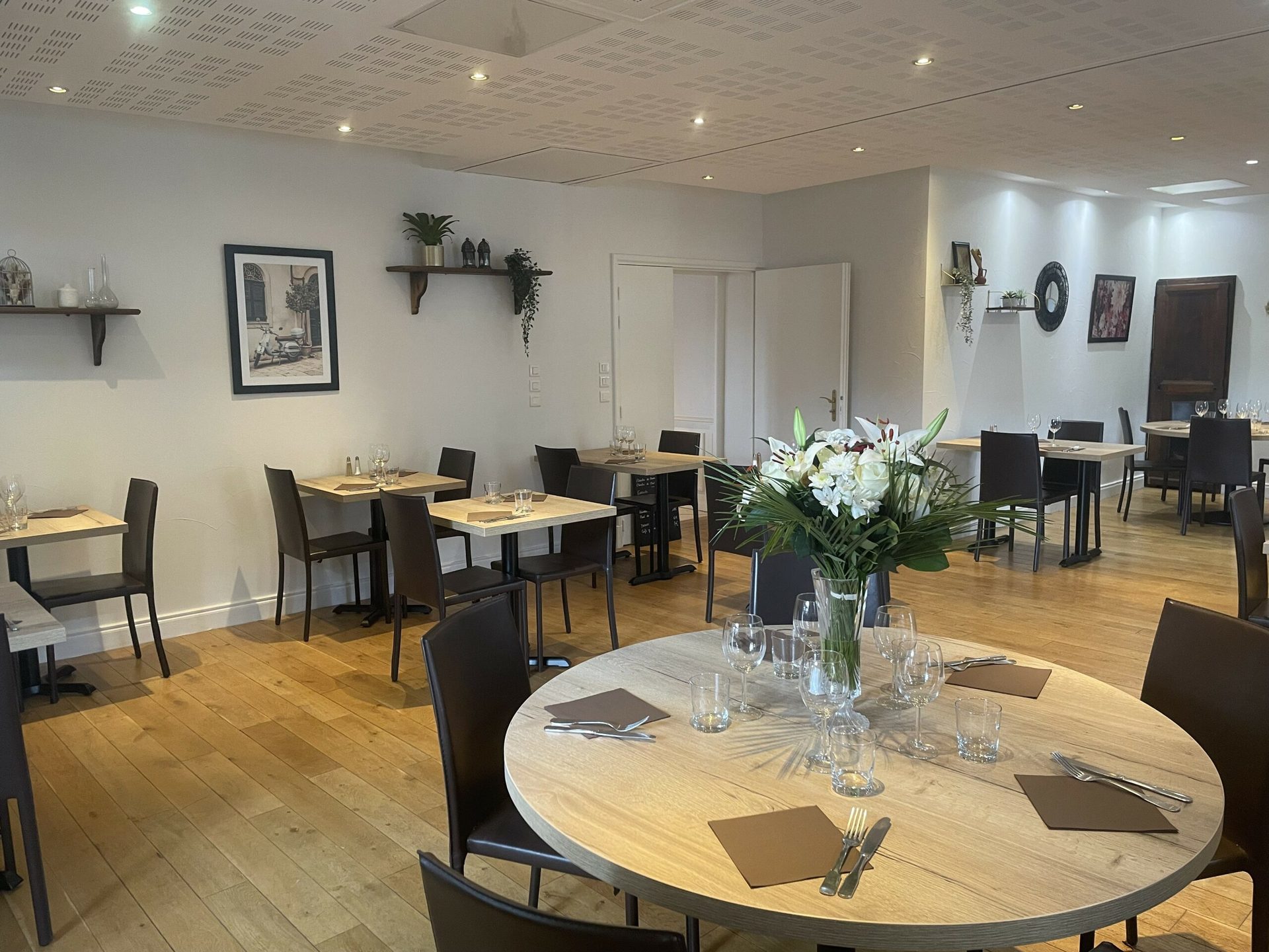Salle du restaurant, table ronde ornée d’un bouquet