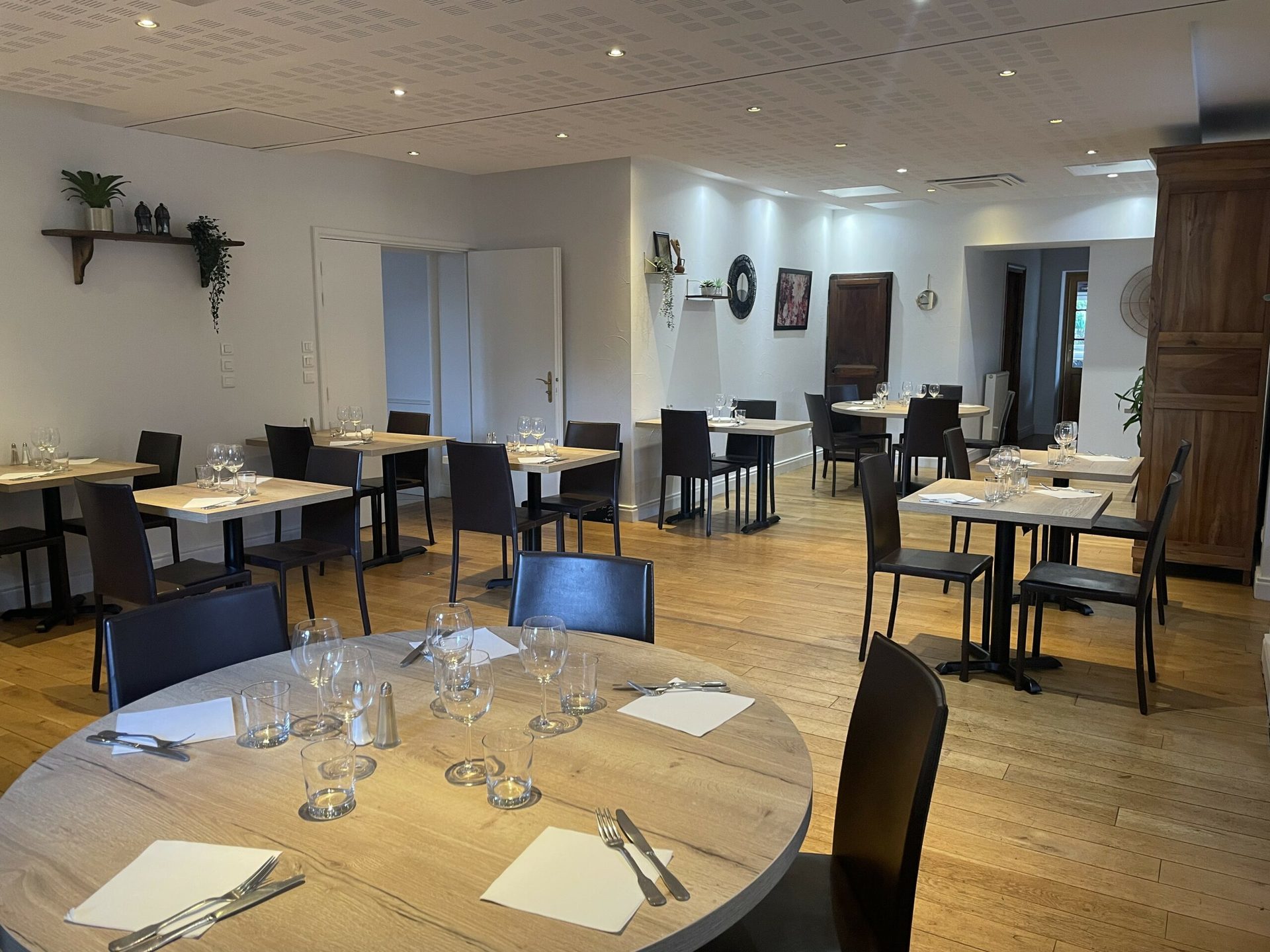 Salle du restaurant avec tables rondes dressées